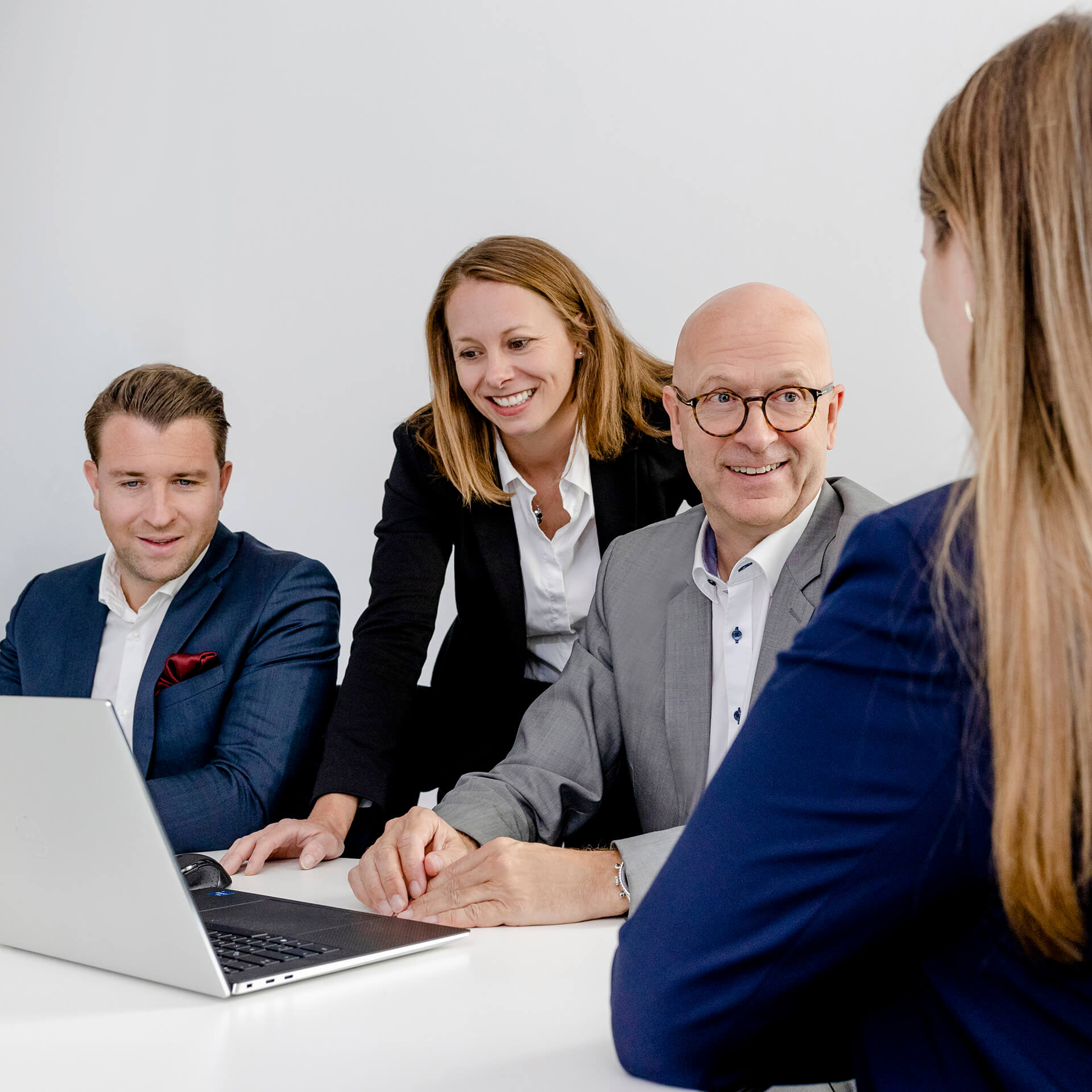 Mitarbeiter der Kanzlei activeMind.legal arbeiten zusammen am Laptop und besprechen einen aktuellen Datenschutzrechtfall